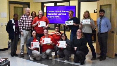 A group of adults from the Choose Love project smiling at the camera