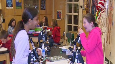 Photo of two girls using microscopes