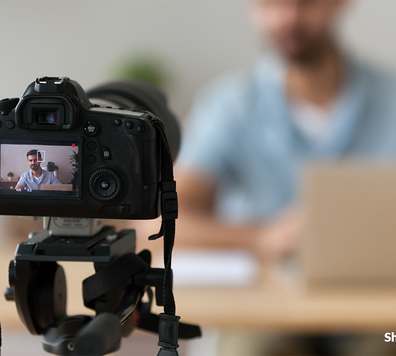 Photo of an educator recording themselves with a video camera