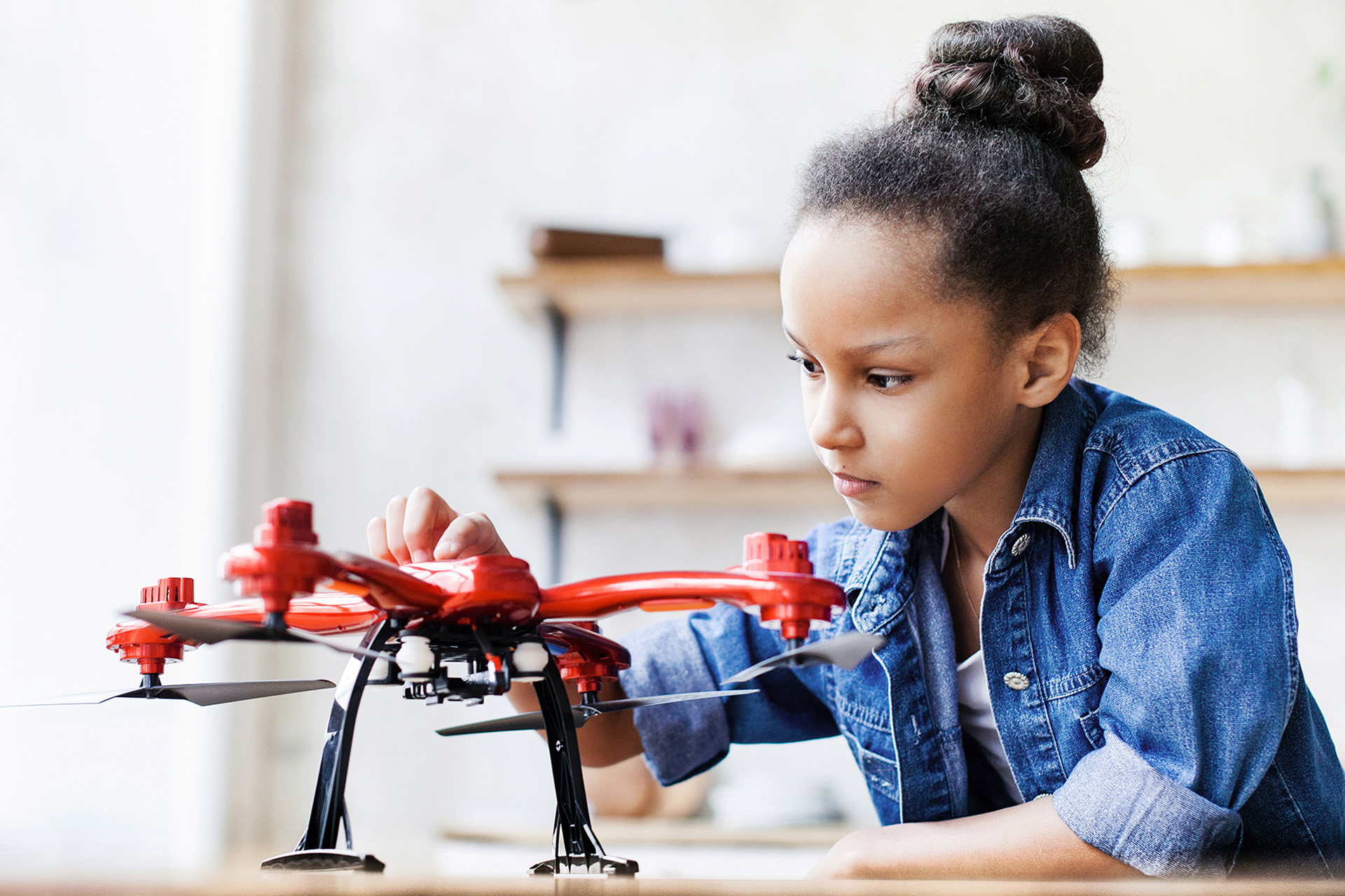 Photo of a young girl exploring the parts of a drone