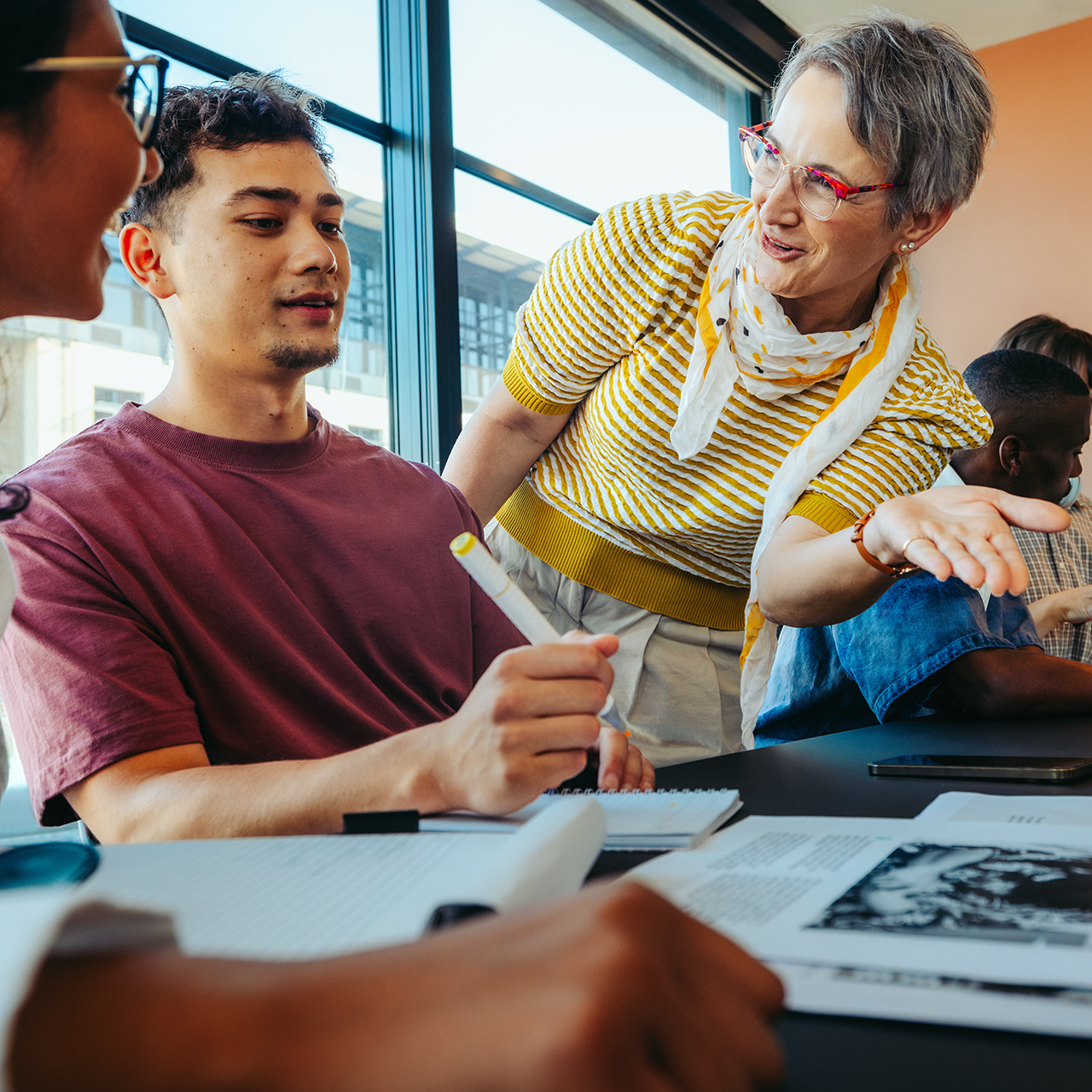 Instructor engaging with two college students